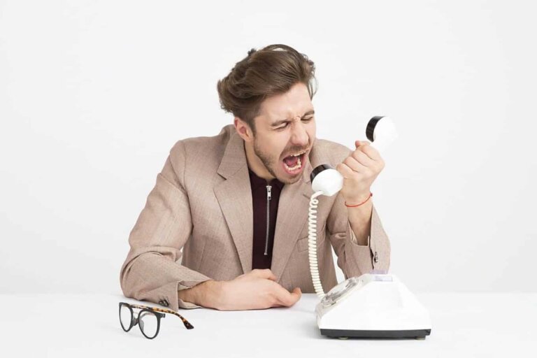 Comunicazione (in)efficace: uomo che urla contro una cornetta del telefono.